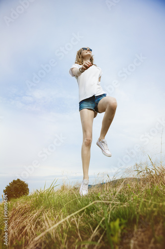 Happy woman jumping on meadow. Beautiful summer day on field.