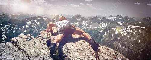 Obraz Człowiek wspinający się po skałach na półce górskiej