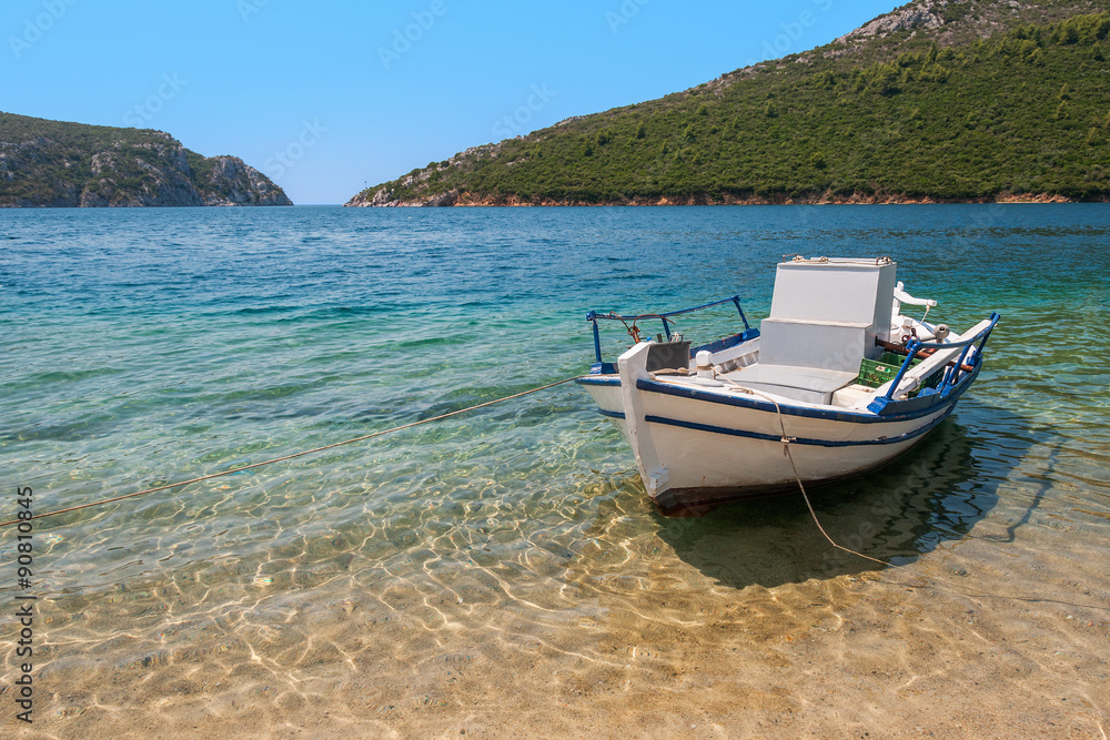 A natural port with a fishing boat anchored by the beach A natural port with a fishing boat anchored by the beach