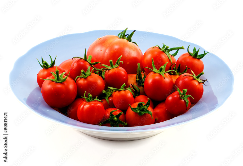 Big blue plate with red tomatoes isolated on white Big blue plate with red tomatoes isolated on white