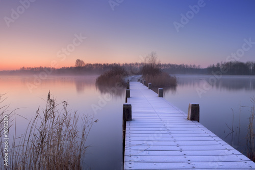 Boardwalk on a lake at dawn in winter, The Netherlands