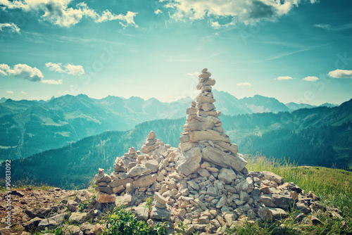 Leinwand Poster Rock Cairns Overlooking Alpine Mountain Range
