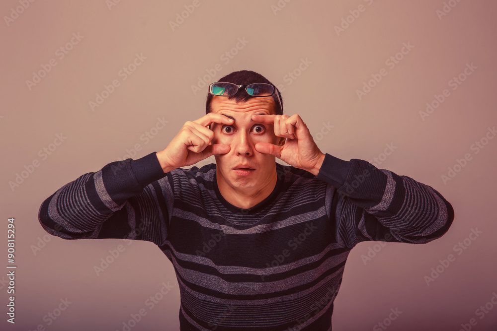 European-looking male of about thirty brunet stretches eyes with European-looking male of about thirty brunet stretches eyes with