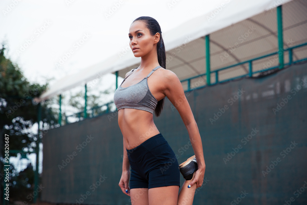 Obraz premium Woman stretching leg outdoors