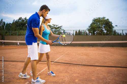 Man training woman to play tennis © Drobot Dean