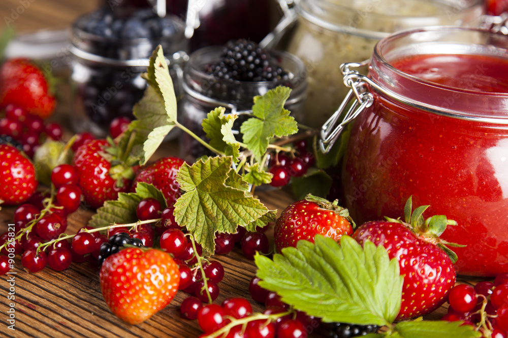 Jams in glass jars with wood and fresh berries Jams in glass jars with wood and fresh berries