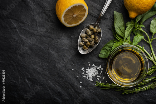 Olive oil with lemon , capers and different greens horizontal