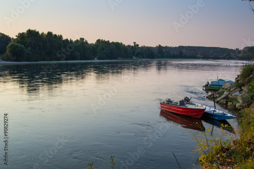 small rusty boats on Ticino River at sunset, Italy. © ngaliero