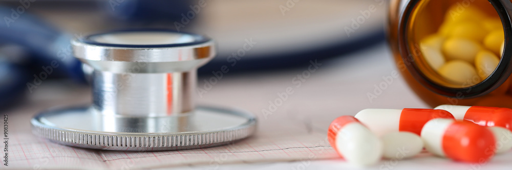 Medical stethoscope head lying on cardiogram chart Medical stethoscope head lying on cardiogram chart