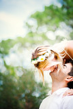 Beautiful happy young couple in white dresses is kissing smiling in the park in summer