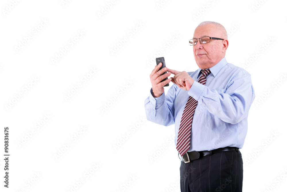 The strong concentrated 75 years old senior businessman in shirt, tie and glasses. Holding cell phone, smartphone in hand and write sms. Free space text in left side. Isolated, plain white background The strong concentrated 75 years old senior businessman in shirt, tie and glasses. Holding cell phone, smartphone in hand and write sms. Free space text in left side. Isolated, plain white background