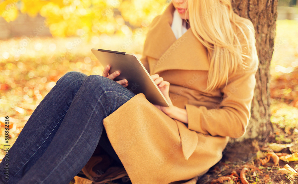 Obraz premium young woman with tablet pc in autumn park