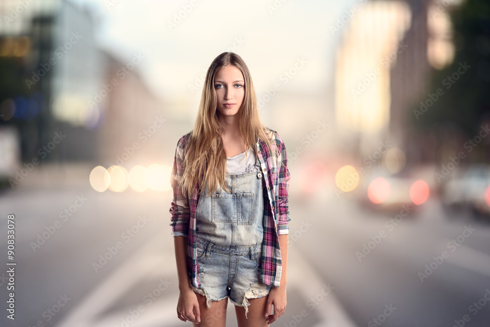 Junge Frau in modischer Kleidung steht an einer Straße