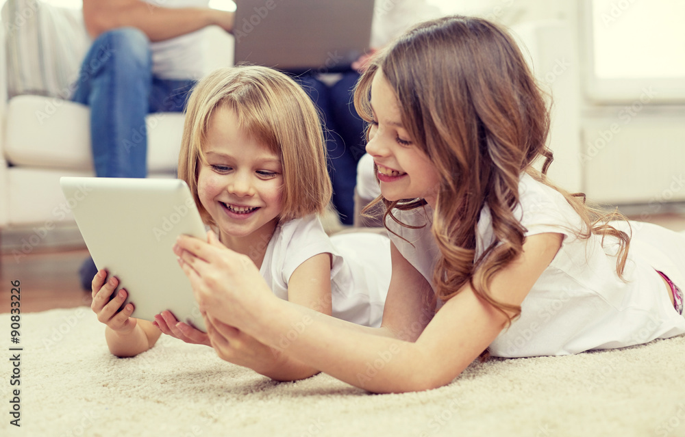 happy little girls with tablet pc computer at home