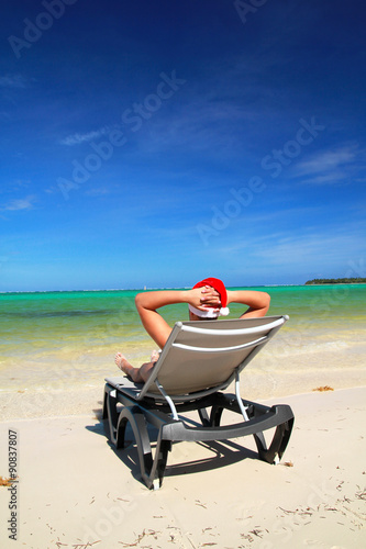 Man in Santa hat on chaise longue