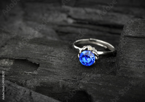 jewellery ring witht big blue sapphir on dark coal background, s photo
