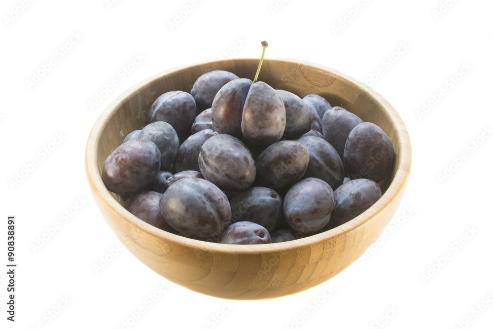  purple plums in a bamboo plate