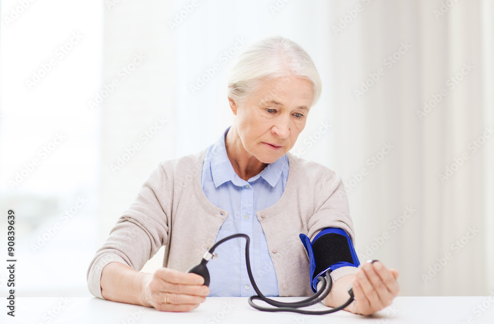 old woman with tonometer checking blood pressure old woman with tonometer checking blood pressure