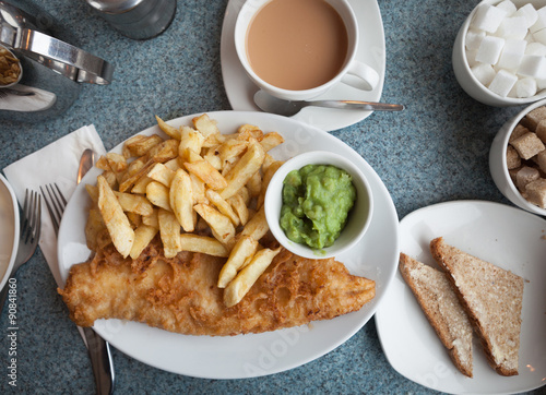 Authentic British fish and chips, with mushy peas, buttered bread and a cup of tea