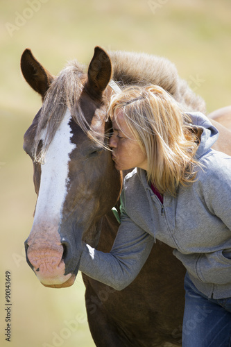 woman long hair kissing beautiful horse