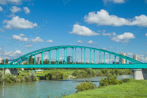 Green Railway bridge over Sava river in Zagreb and modern skyline © ilijaa
