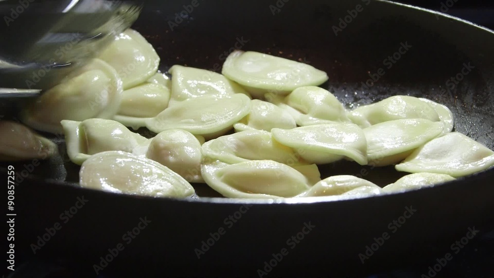 Cooking perogi dumplings in frying pan on stovetop oven Cooking perogi dumplings in frying pan on stovetop oven
