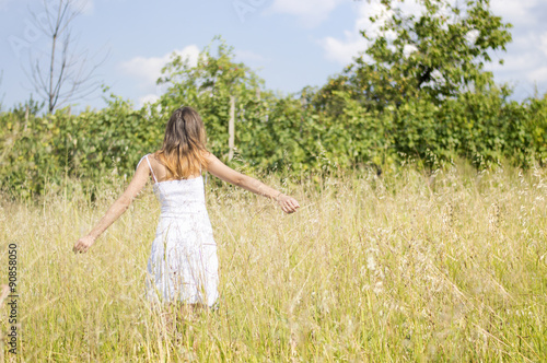 Young woman in the field wearing white dress