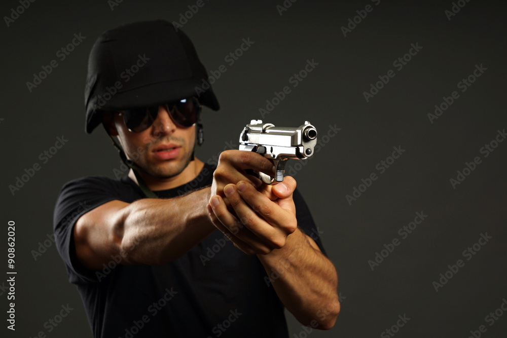 Special ops officer SWAT in black uniform, focus is on gun barrel Special ops officer SWAT in black uniform, focus is on gun barrel