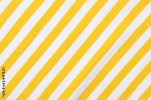 White and yellow striped background. Diagonal stripes pattern on fabric.