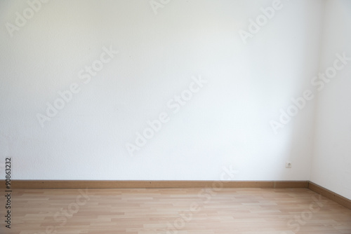 Corner of an empty room in white with parquet floor