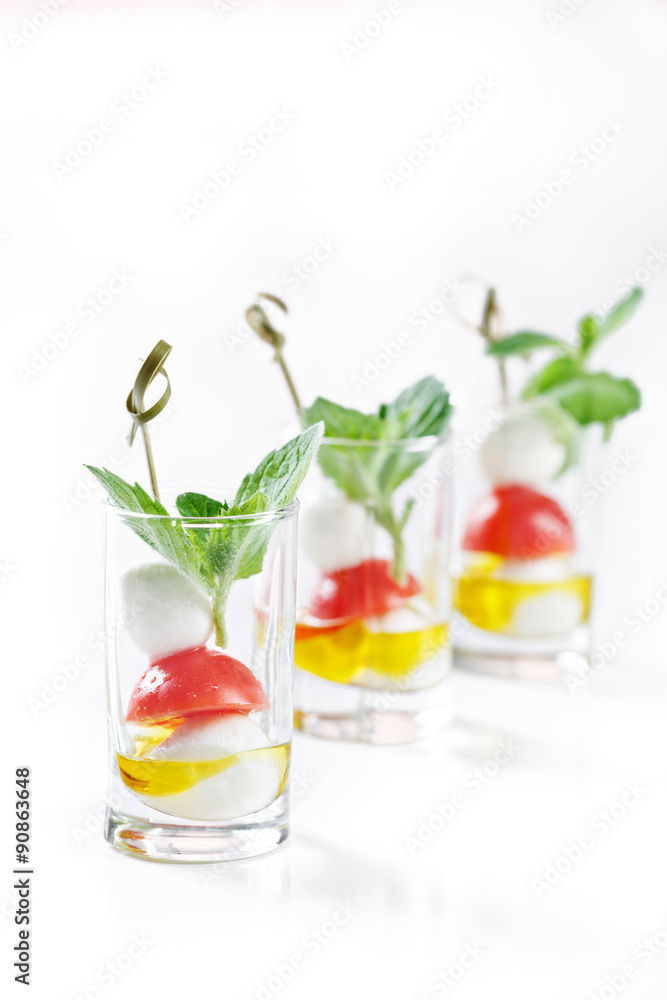 set of canapes in glass with mozarella, tomato and olive oil greece salad