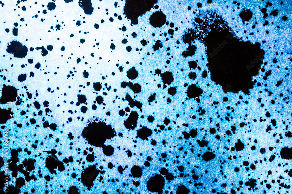 Black ink stains on blue paper.