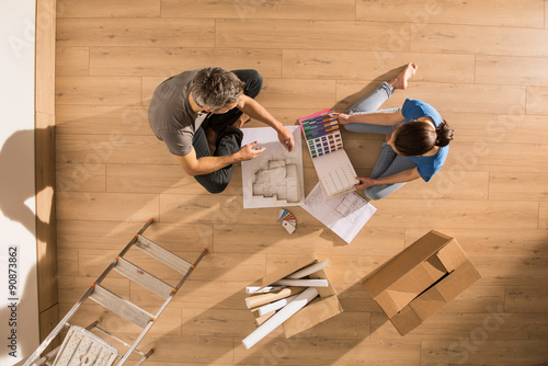 Fotografie top view couple sitting on floor thinking on decorating home