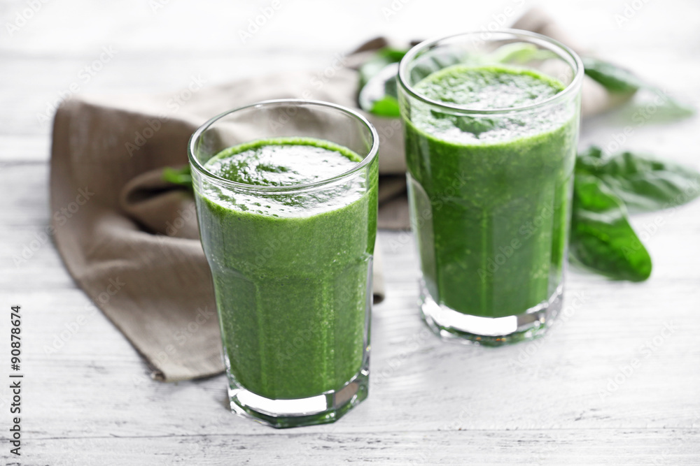 Glasses of spinach juice with napkin on wooden table, closeup Glasses of spinach juice with napkin on wooden table, closeup