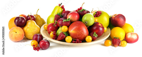 Heap of fresh fruits and berries on plate isolated on white