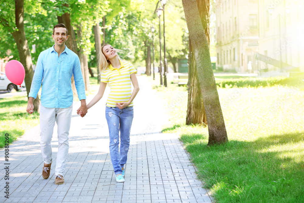 Young pregnant woman with husband walking outdoors Young pregnant woman with husband walking outdoors