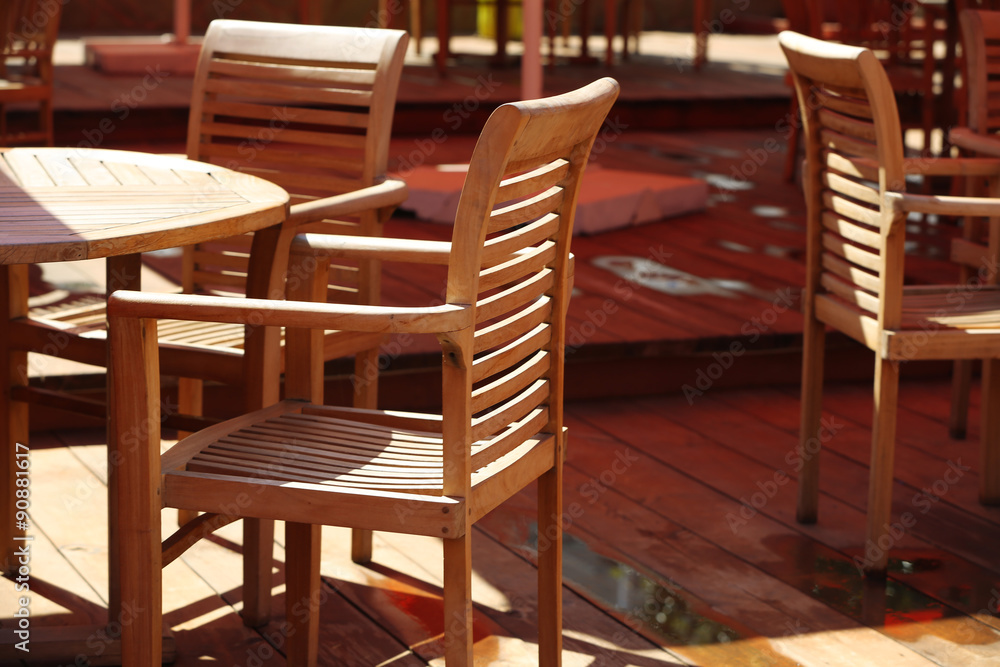 Wooden chairs and tables on summer restaurant terrace
