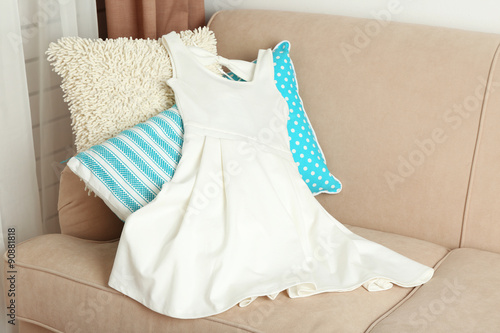 White female dress on sofa in room © Africa Studio