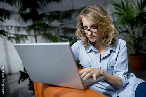 Beautiful young businesswoman laptop in office, she is focused, tryingto solve problem