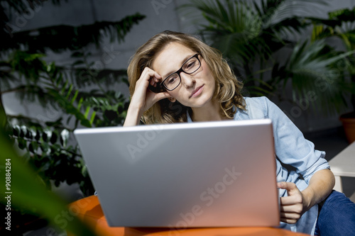 Beautiful young businesswoman using laptop in office with upset experssion on face