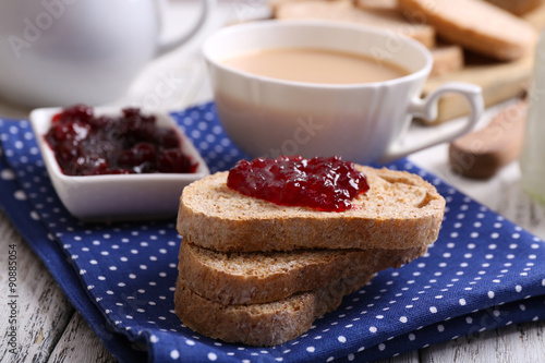 Fresh toast with jam and cup of coffee on table close up