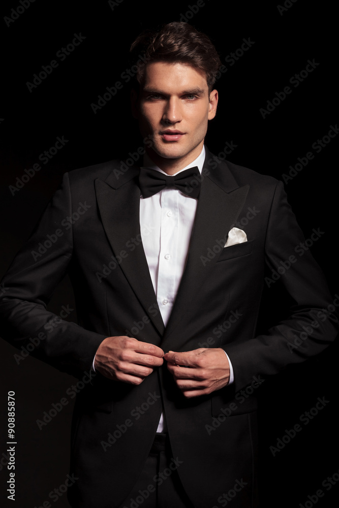 young elegant man closing his jacket. young elegant man closing his jacket.