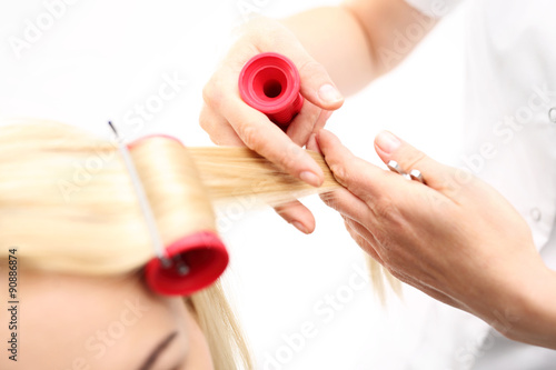 Kobieta u fryzjera, kręcenie włosów na termoloki.Kobieta w salonie fryzjerskim, fryzjer kręci włosy na wałki 