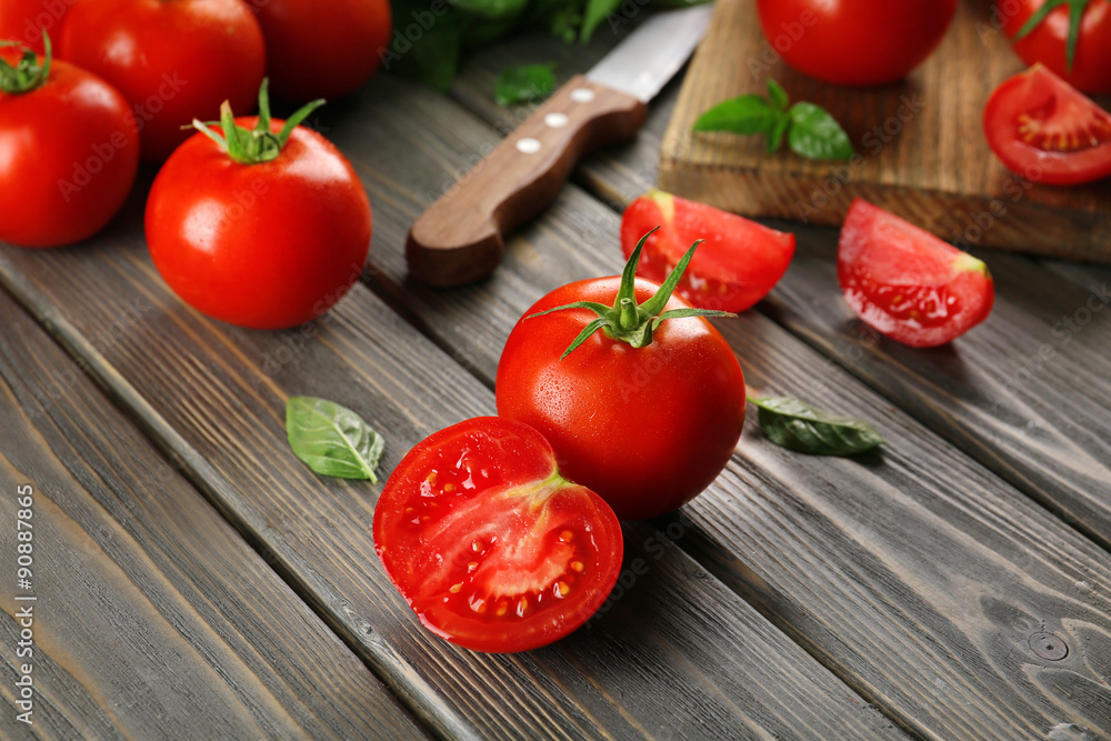 Red tomatoes and knife on wooden background Red tomatoes and knife on wooden background