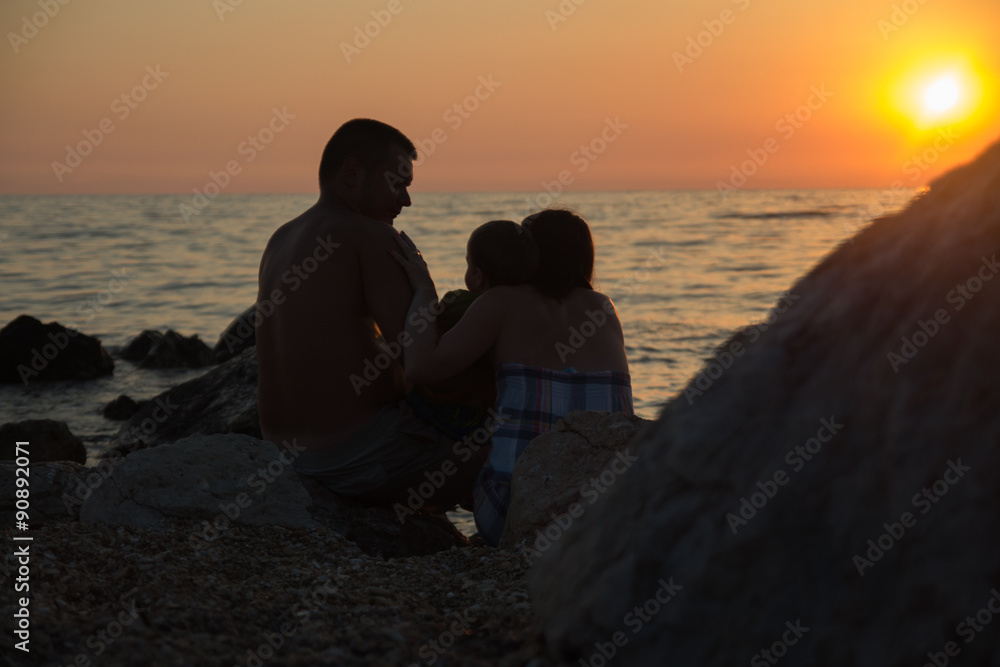 Family at sunset watching the sea
