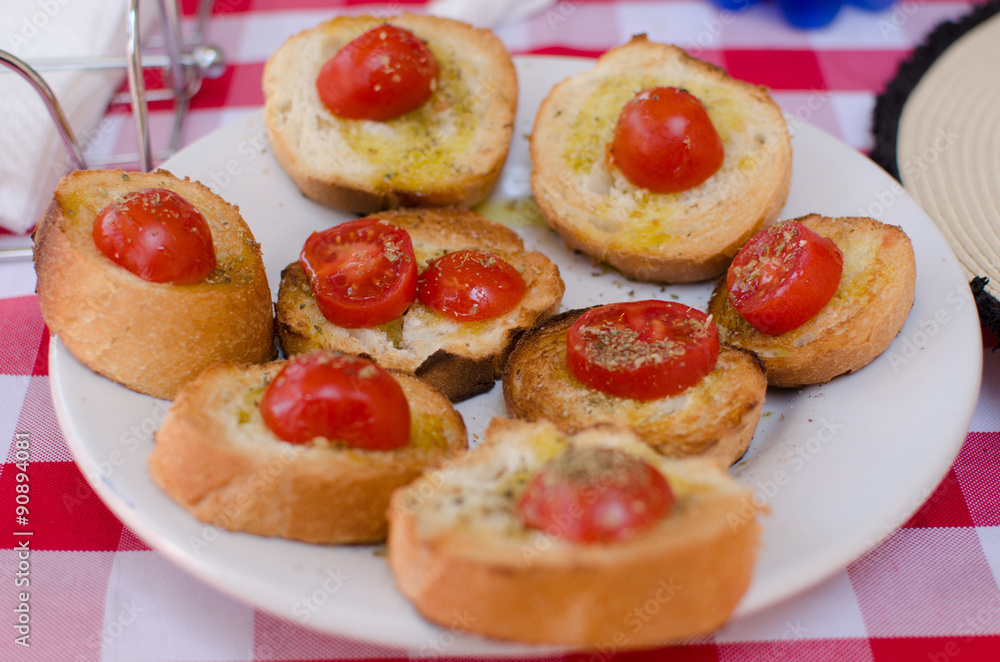The dish with crisp bread with tomatoes, herbs and oil The dish with crisp bread with tomatoes, herbs and oil