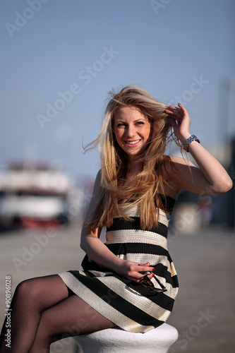 Elegant woman in a beautiful dress sitting at a river