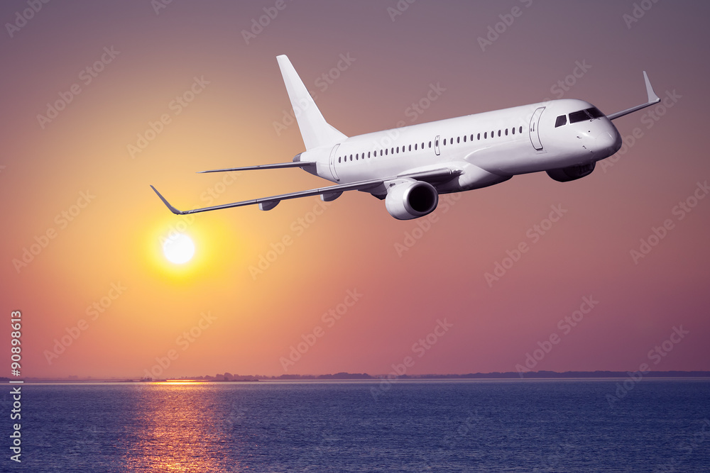 Fototapeta premium Samolot pasażerski lecący na zachód słońca