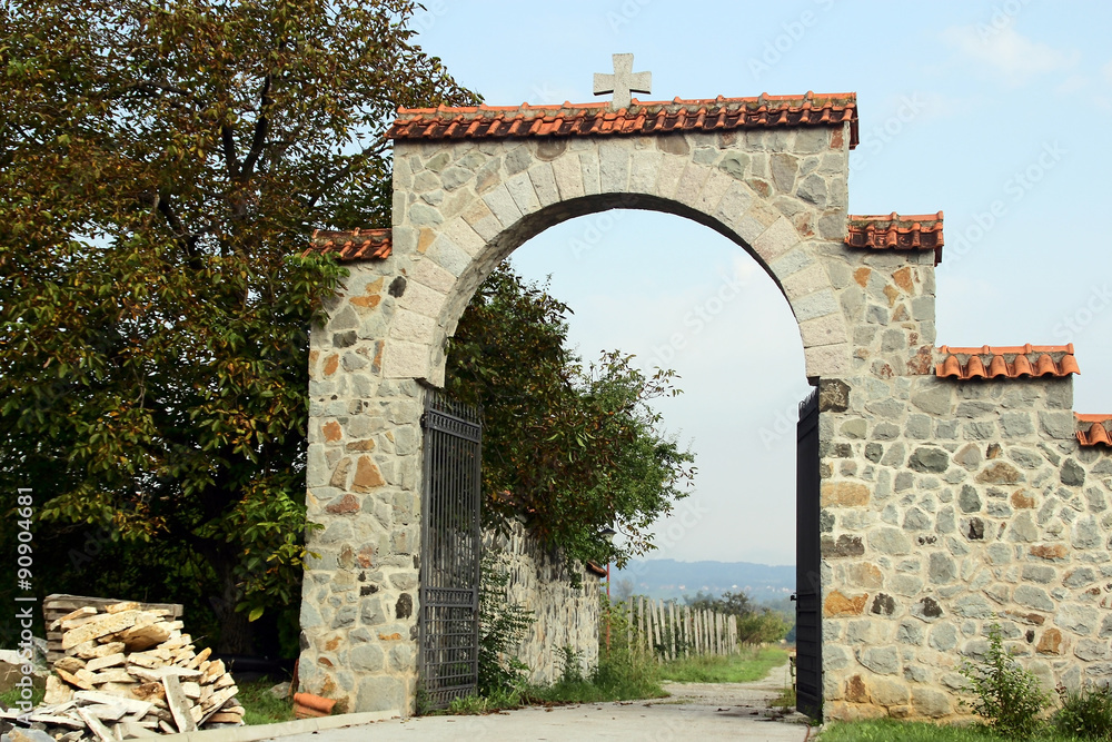 The stone wall and the gate in the monastery garden