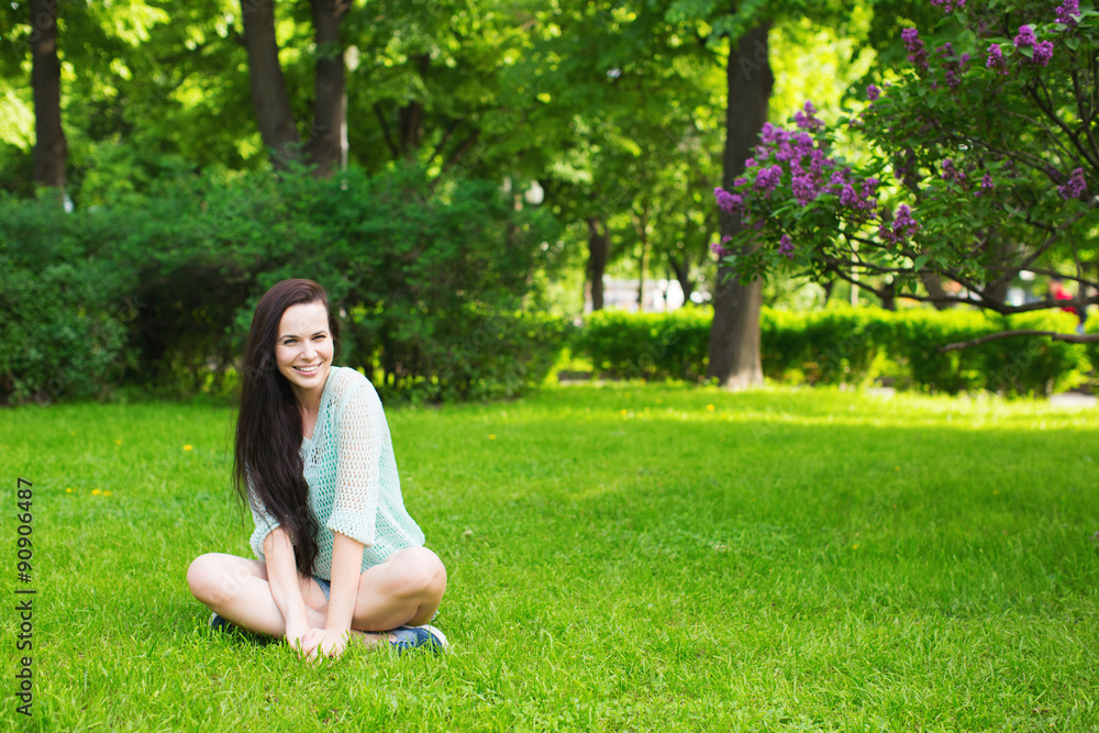 Fototapeta premium Girl student smiling sitting on the grass